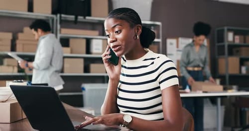 Smiling Woman Talks on Phone While Using Laptop