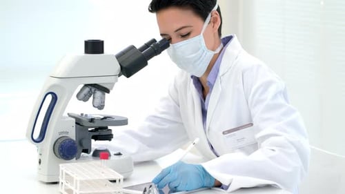 Female Scientist Using Microscope in Lab