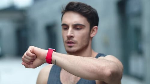 Man Checking Smartwatch While Exercising Outdoors