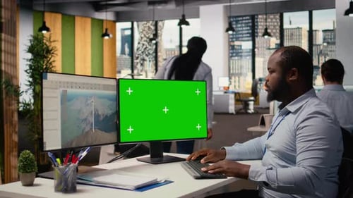 Techniker arbeitet am CAD-Design von Windturbinen mithilfe eines Greenscreen-PCs