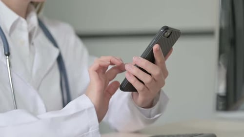 Close up of Female Doctor using Smartphone for Browsing Internet
