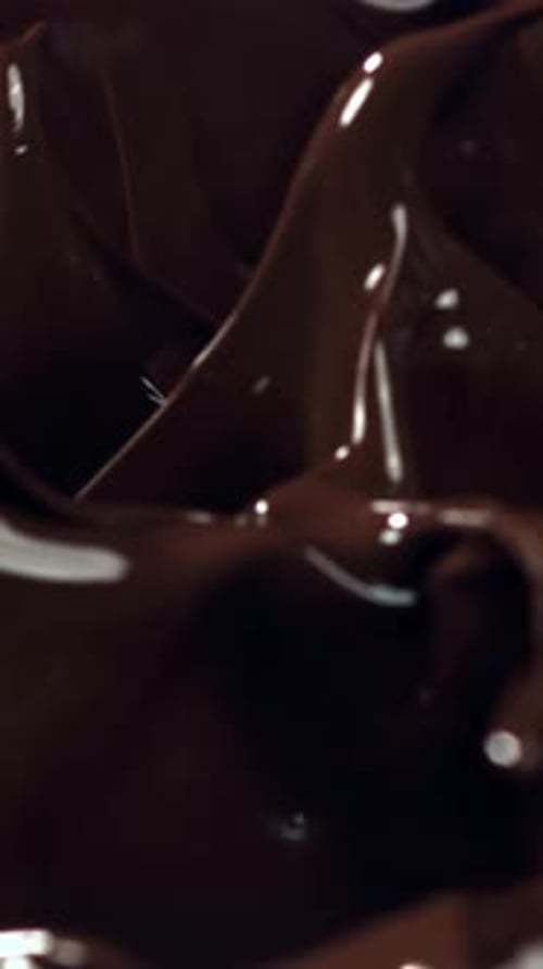 Pieces of Chocolate Fall Into the Melted Chocolate Filmed on a Highspeed Camera at 1000 Fps