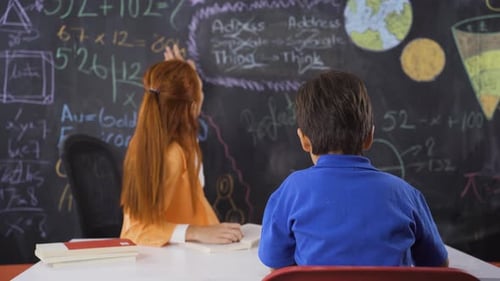 Dedicated Teacher Tutoring a Young Boy in Classroom