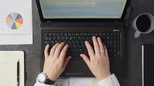 Gros plan de mains masculines tapant sur un ordinateur portable au travail