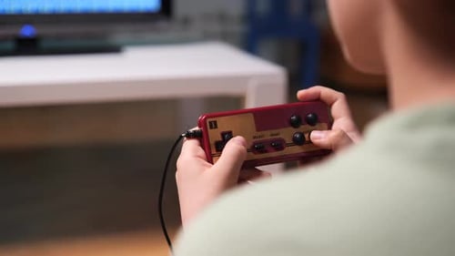 Teen Plays Retro Video Game with Controller