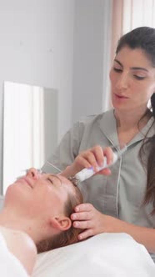 Woman Receiving Facial Ultrasonic Skincare Treatment in Clinic