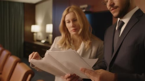 Two Lawyers Standing Next to Each Other and Discussing Documents