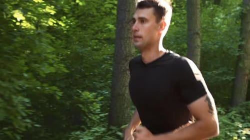 Young Man Jogging in a Park During Summer for a Healthy Workout