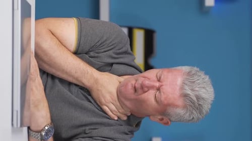 Vertical video of Home office worker man suffering from sore throat.