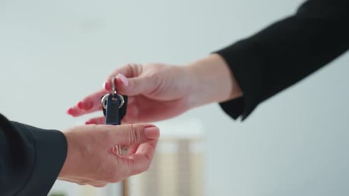 Business Expert Handing Over Property Key to Client in Office