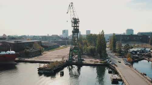 Drone flying around big crane in the shipyard docks