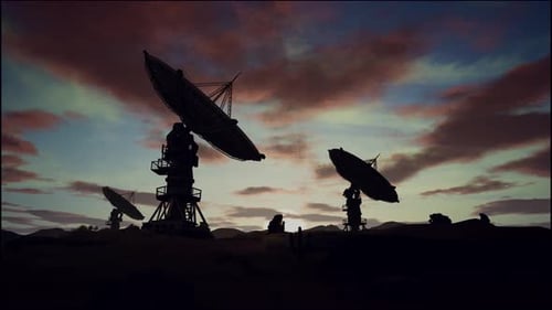 Satellite Dishes On Field Against Cloudy Sky During Sunset