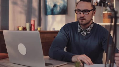 A Focused Professional Individual Works Diligently on a Laptop in a Modern Office