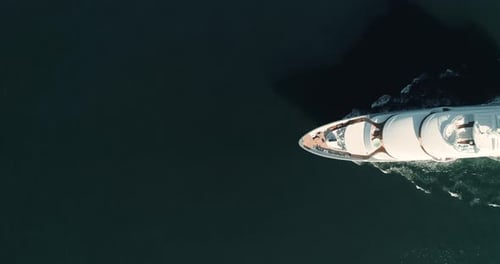 Aerial footage of yacht passing from right to left. Top Down view, wide angle. Large yacht sailing p