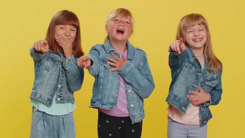 Three Happy Children Pointing and Laughing in Studio