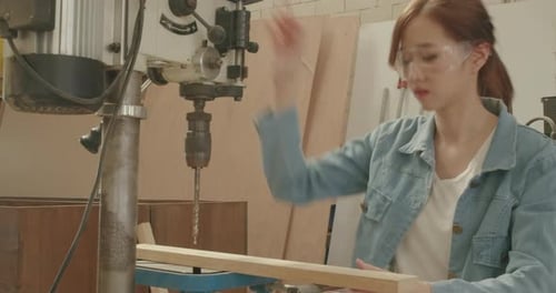 Worker young woman carpenter building design and drilling wooden