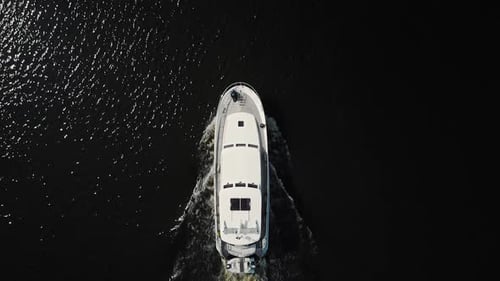 Luxurious white yacht sailing on water, top view