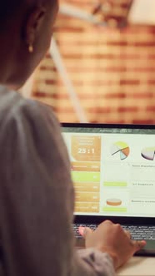 Analyzing Business Data and Charts on Laptop