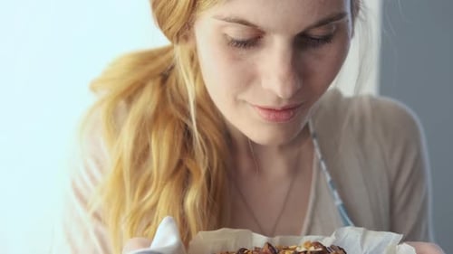Woman Smelling Freshly Baked Fruit and Nut Dessert