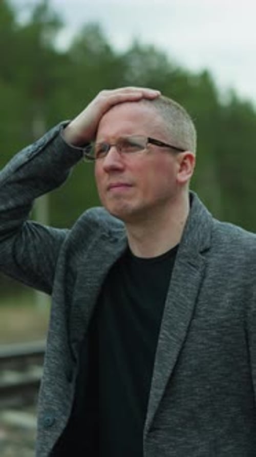 Man Walking on Railroad Tracks Wearing a Blazer