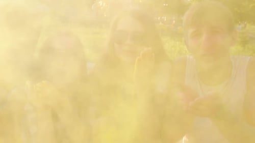 Friends Celebrating Holi Blowing Colorful Powder Together