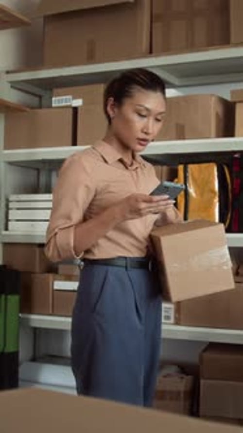 Vertical of Manager Working on Smartphone at Warehouse