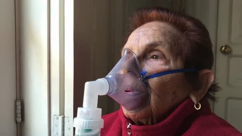 Zoomez sur le visage d'une dame âgée caucasienne utilisant un masque facial pour un traitement par inhalation