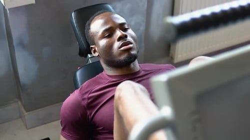 Black Man Weightlifter Doing Leg Presses in Gym