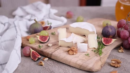 Cheese and Fruits on a Wooden Cutting Board