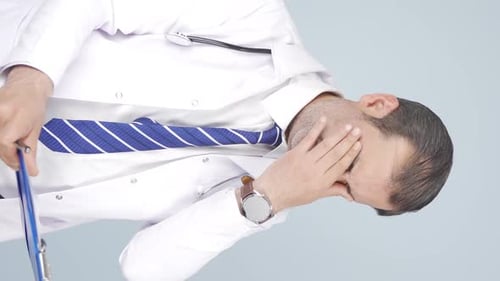 Tired Doctor Rubbing Eyes, Holding Clipboard