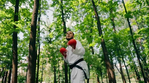 Outdoors in the Park in Sunny Weather Young Karate Guy Dressed in Red Combat Boots and Gloves