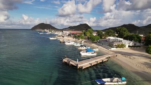 Aerial Backward Motion Over Boats and Beachfront to Mountain View