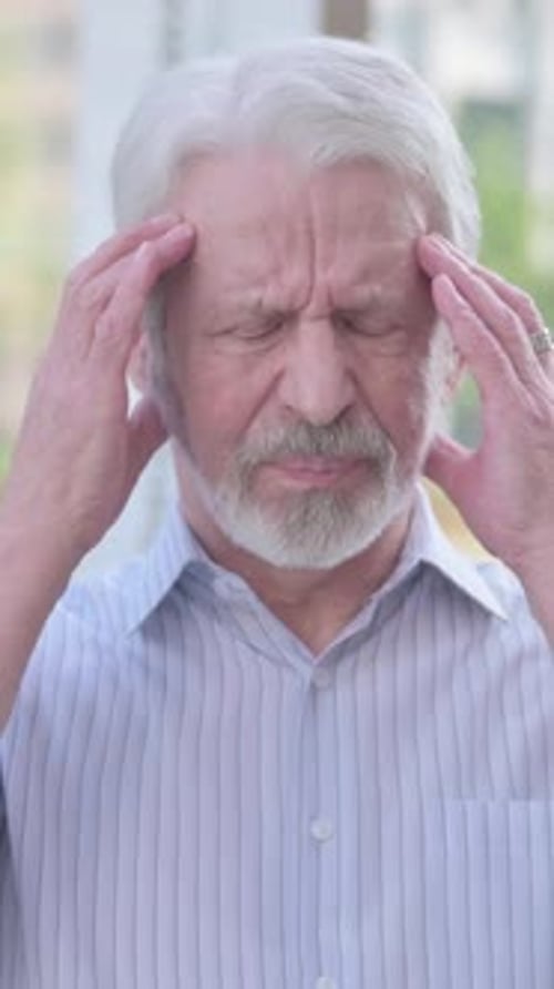 Senior Man Massaging Temples with Headache Pain