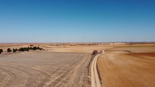 Aerial view of dirt path. Drone footage in Castilla la Mancha, land of don quijote, vineyards, flat