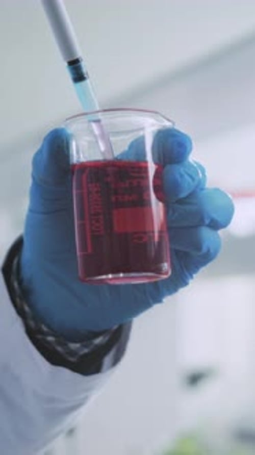 Réalisation d'un pipetage de liquide précis avec des gants pour préparer des échantillons chimiques à des fins expérimentales