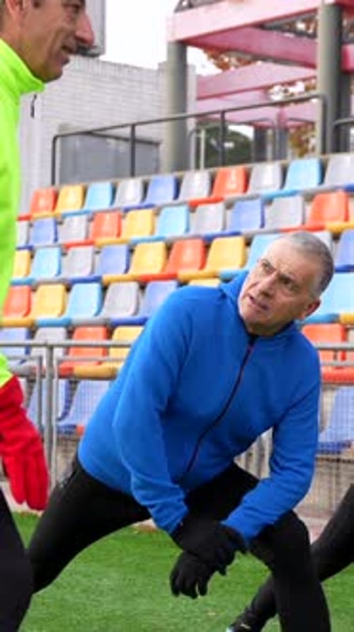 Two Senior Men Stretching on a Track