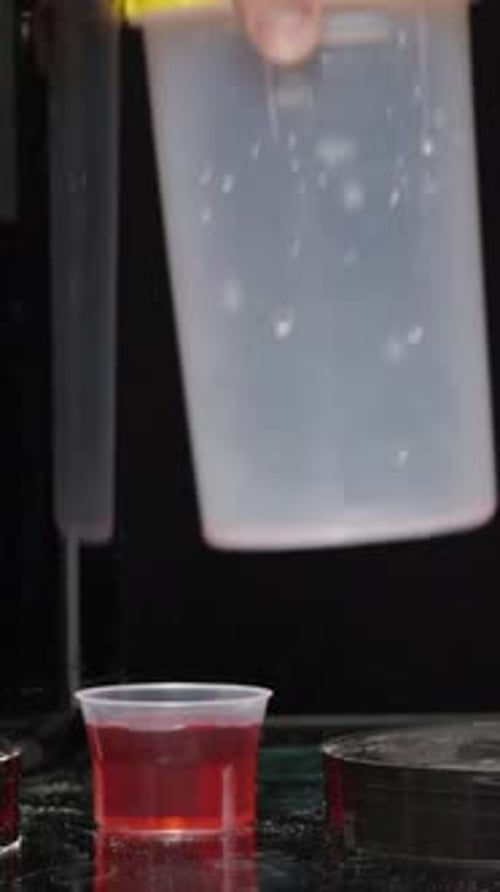 Vertical video. Black Cans With Sports Supplements On The Table, A Man Takes A Spoon Of Protein