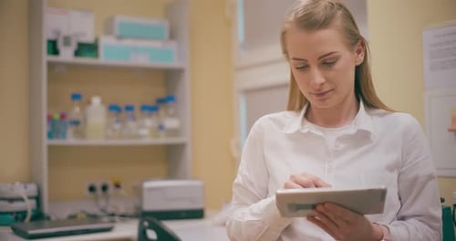 Woman Using Tablet in Lab for Medical Research