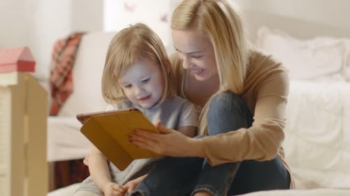 Smiling Mother and Child Using Tablet at Home