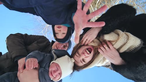A Young Family Throws Snow at the Lens on a Winter Day