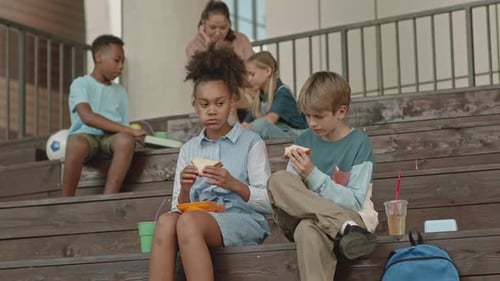 Students eating lunch together on school steps