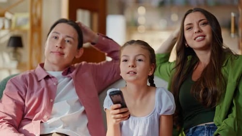 Family Watching TV and Cheering Together Indoors