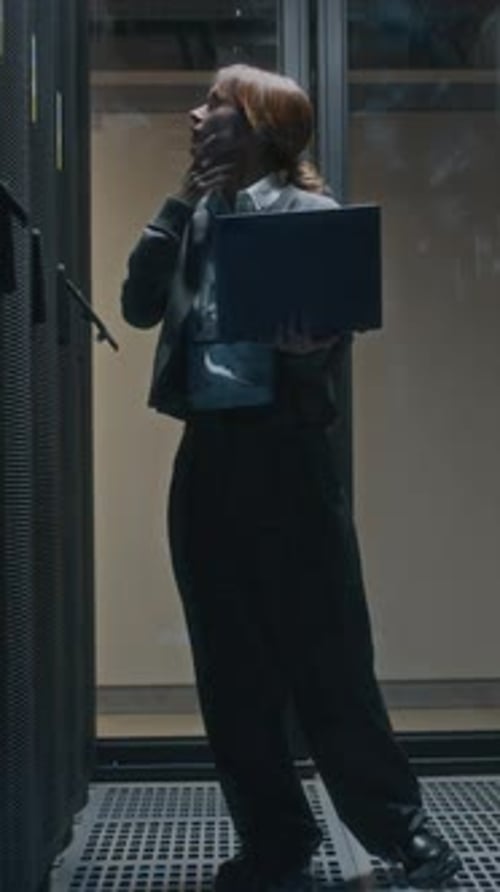 Vertical of Female Data Center Administrator Checking Rack Server Cabinets