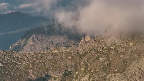 Majestic Mountain Peak Partially Covered By Moving Clouds