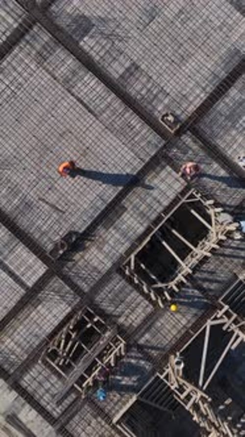 Vertical Video Workers on Scaffolding Preparing Framework for Concrete Floors Captured Vertically at