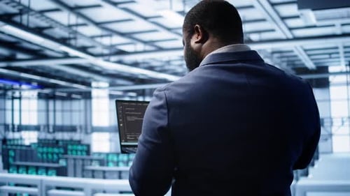 Programmer in Data Center Doing Yearly Maintenance Checkup Using Laptop