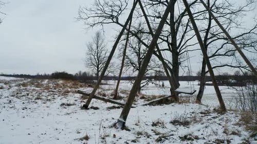 Scary view of swing move by itself at outdoor playground, winter landscape