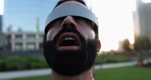 Man with beard wearing futuristic visor outdoors