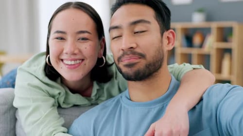 Smiling Couple Waving and Talking to Camera Indoors
