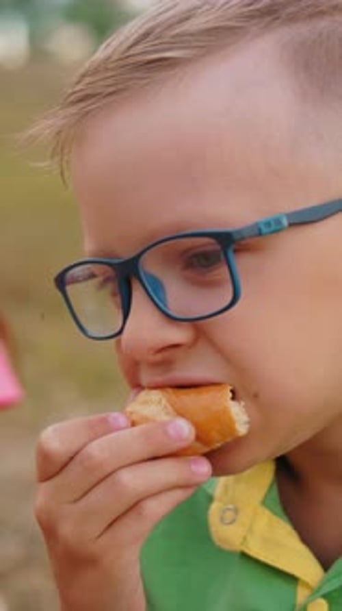 Child Eating Pastry Snack Outside in Park